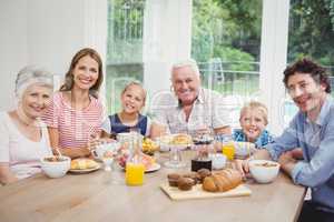 Multi-generation family sitting at table during breakfast