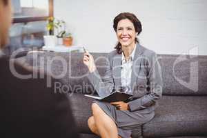 Smiling businesswoman sitting on sofa in office