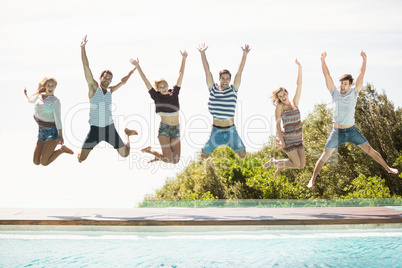 Group of friends jumping at poolside