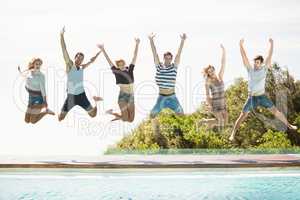 Group of friends jumping at poolside