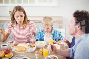 Children having breakfast with parents