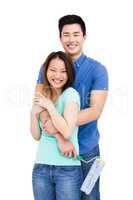 Young couple standing with paint roller