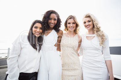 Well dressed women posing next to a limousine