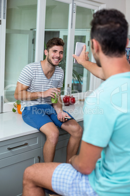 Man showing phone to smiling friend