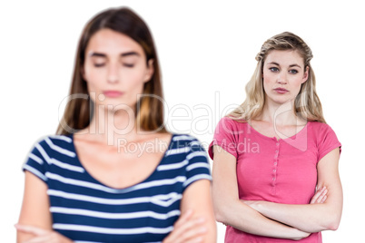 Upset female friends with arms crossed