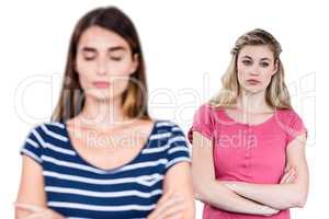 Upset female friends with arms crossed