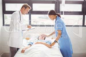 Doctor and a nurse examine a patient