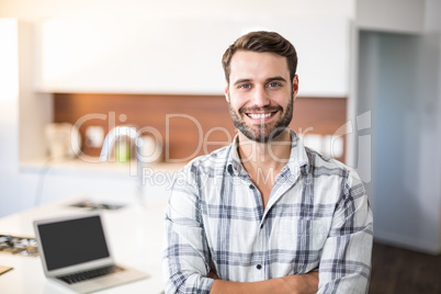 Confident young man by kitchen counter