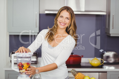 Portrait of smiling young woman using juicer