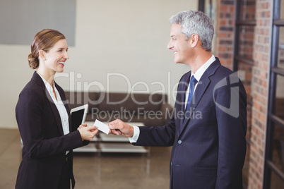Businesswoman giving business card to client in office