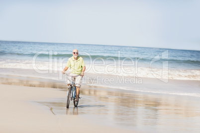 Smiling senior man riding bike