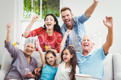 Family cheering while watching television