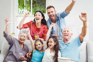 Family cheering while watching television