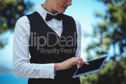 Smiling waitress taking an order with a tablet