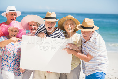 Senior friends holding blank paper