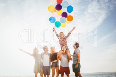 Portrait of friends holding balloon