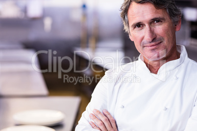 Smiling chef with hands crossed in the kitchen