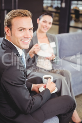 Businessman and businesswoman having tea during breaktime