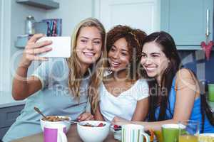 Cheerful female friends taking selfie