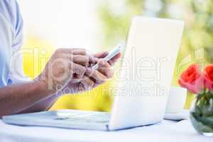 Casual businessman using laptop and smartphone