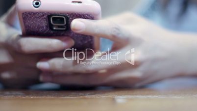 Soft focused girl's hands browsing and texting smartphone