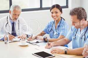 Medical team writing a report in conference room