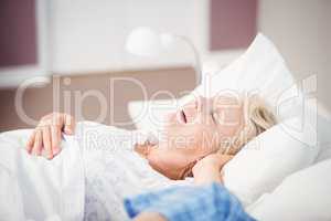 Woman snoring on bed next to husband