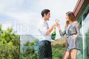 Couple toasting champagne at balcony