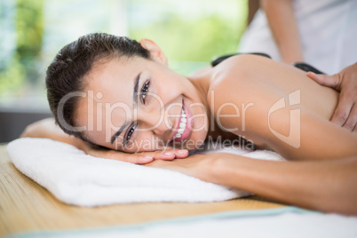 Woman smiling while receiving stone massage