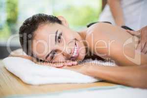 Woman smiling while receiving stone massage