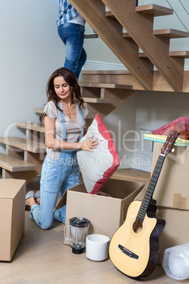 Woman unpacking cushion from cardboard box