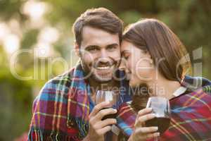 Young couple with wine wrapped in blanket