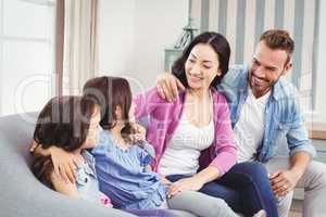 Parents sitting with children on sofa