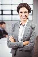 Confident businesswoman with arms crossed in office