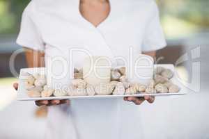 Masseur holding tray with pebbles and candles