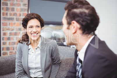 Cheerful business professionals sitting on sofa