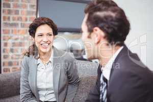 Cheerful business professionals sitting on sofa