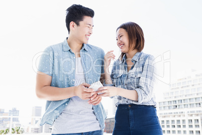 Happy young couple using mobile phone