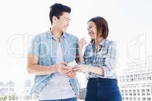 Happy young couple using mobile phone