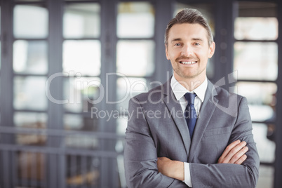 Smiling businessman with arms crossed in office Smiling businessman with arms crossed in office