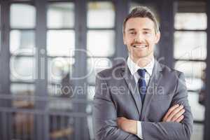 Smiling businessman with arms crossed in office