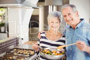 Portrait of happy senior couple with cooking pan