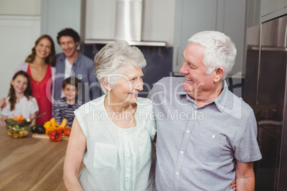 Happy grandparents with family in kitchen