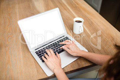 Woman typing in laptop at table