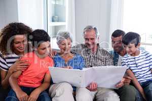 Happy family sitting on sofa and looking at photo album