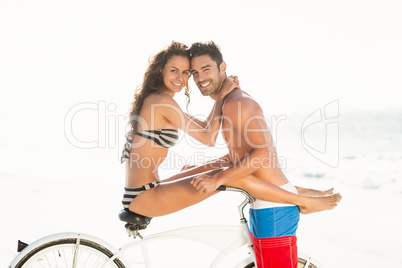 Couple posing with bike on the beach