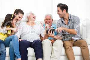 Family laughing while looking at smartphone photos