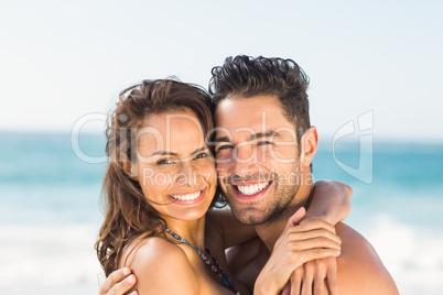 Happy couple hugging on the beach