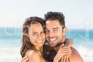 Happy couple hugging on the beach