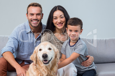 Happy parents with son and pet in living room
